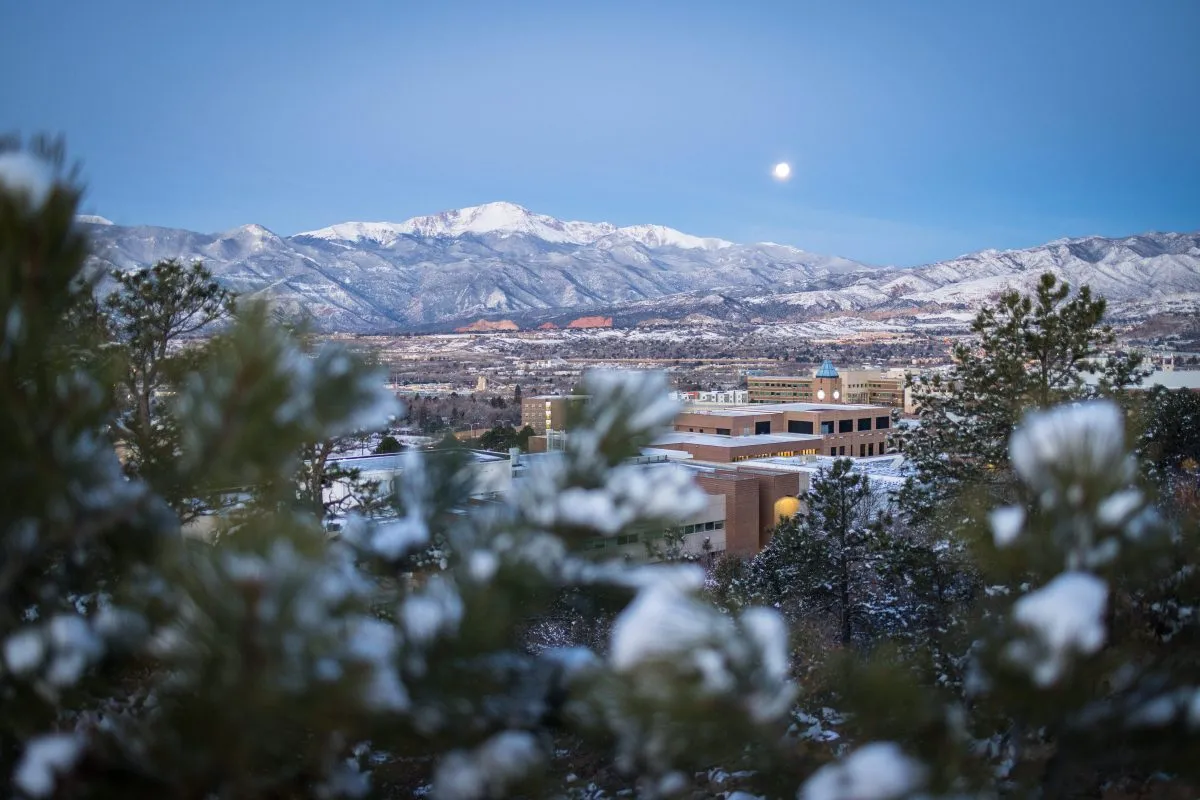 UCCS campus with the snow-covered Pikes Peak in the background in the early morning.
